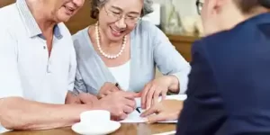 Couple signs documents with Senior Placement Referral Specialist